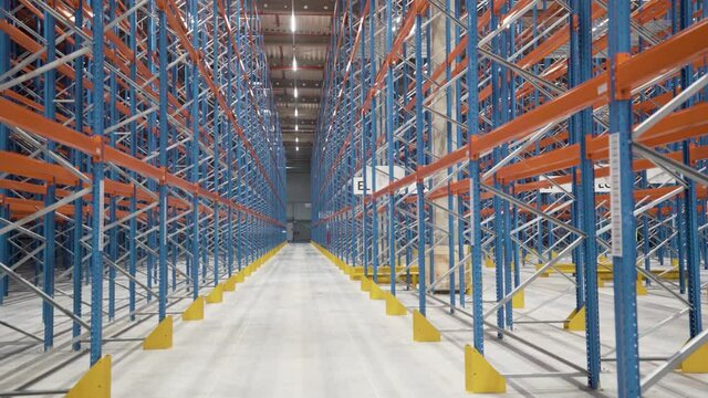 Warehouse, storage racks and shelves industrial logistic delivery. Large logistics warehouse. Shooting between metal shelves in a huge logistics center- Aerial 