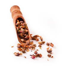 Dried cherry blossom tea in a wooden scoop isolated on a white background.