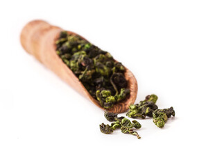 Tieguanyin chinese Oolong tea in a wooden scoop isolated on a white background