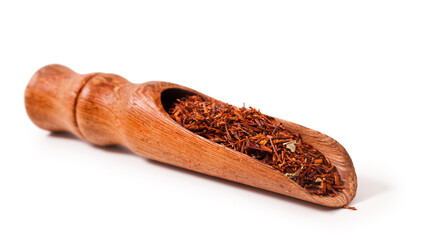 Rooibos tea in a wooden scoop isolated on a white background.
