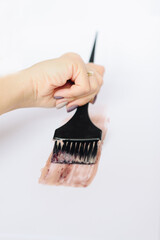 Black brush with hair dye on a white background