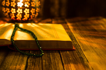 Holy Koran - Quran and rosary beads on the background with candle for Islamic concept. 