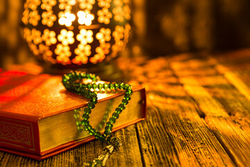 Holy Koran - Quran and rosary beads on the background with candle for Islamic concept. 