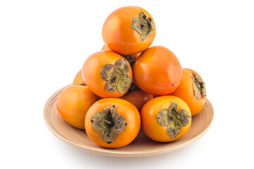 Pile of fresh raw persimmon fruit on wooden plate, isolated on white background 