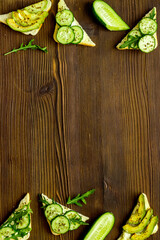 frame of avocado sandwiches on wooden kitchen table top view copy space