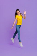Fototapeta na wymiar Joy Of Youth. Cheerful Asian Girl Jumping In Air Over Purple Background