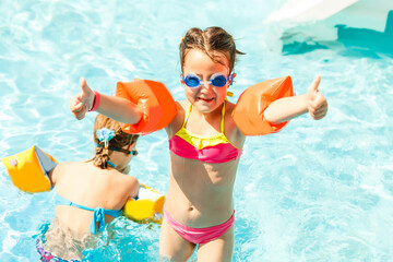 Cute toddler girl playing in swimming pool