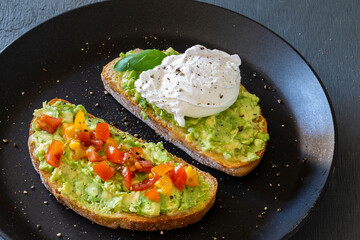 Tasty sandwich with poached egg, avocado and tomatoes