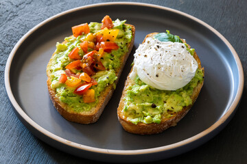 Tasty sandwich with poached egg, avocado and tomatoes