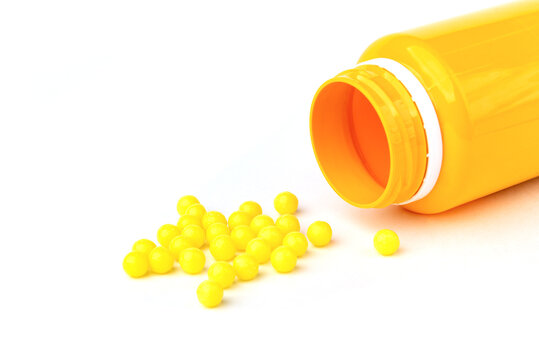 Yellow pills isolated on white background.