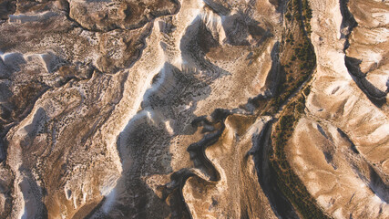 Top view aerial photo from flying drone of a beautiful arid rocky mountains in Kazakhstan National Park during evening twilight. Amazing nature landscape as perfect wallpaper for travel website