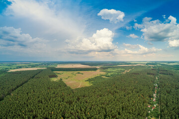 Fototapeta na wymiar Rural landscape, aerial view, skyview of countryside and pine forest with partially cloudy sky