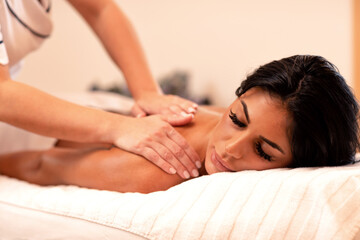 Obraz na płótnie Canvas Tanned sexy woman enjoying her massage