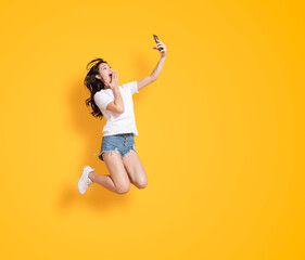  young woman jumping while watching the mobile phone