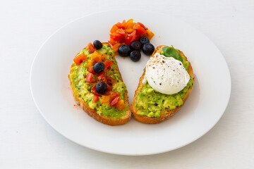 Tasty sandwich with poached egg, avocado and tomatoes
