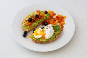 Tasty sandwich with poached egg, avocado and tomatoes
