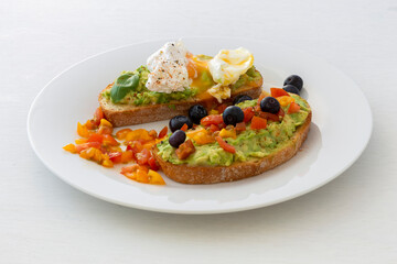 Tasty sandwich with poached egg, avocado and tomatoes
