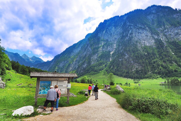 Fototapeta na wymiar wooden gate map Sign pole in Lake Konigssee with many of tourist people walking to the mountain