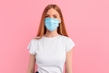 woman in a medical protective mask on her face, on a pink background. The epidemic of coronavirus