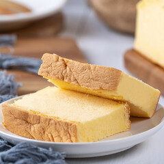 Plain classic Taiwanese traditional sponge cake (Taiwanese castella kasutera) on a wooden tray background table with ingredients, close up.