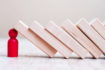 Red wooden Man stop falling blocks on table. fall Business, planning, Management, Leader, Insurance, teamwork and strategy Concepts