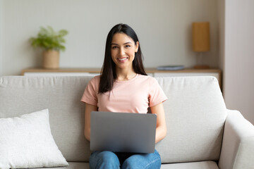 Cheerful Girl Sitting With Laptop On Couch Working From Home