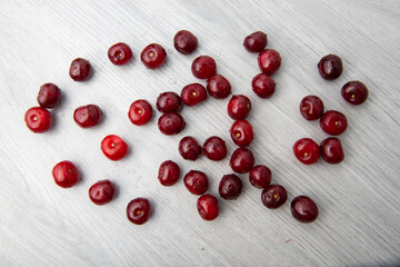 ripe cherry scattered on a light wooden table