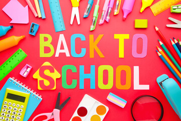 School supplies with inscription back to school on red background