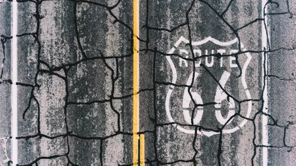 Fototapete Route 66 Bird’s eye view of painted on cracked asphalt roadside number sign of American landmark Route 66, aerial top view view of old retro sign on interstate asphalt highway of famous in USA  © BullRun