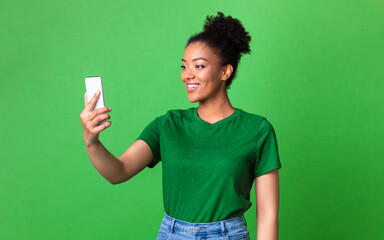 Happy black girl using mobile phone at studio