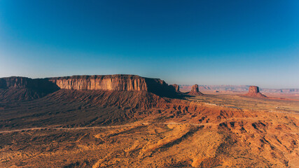 Fototapeta na wymiar Bird's eye view of beautiful landscapes of southwest USA with blue sky on horizon.Aerial view of endless Monument Valley desert of Utah state