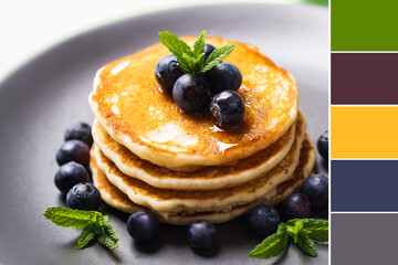 Stack of home made pancakes served with fresh berries and maple syrup. Color swatch