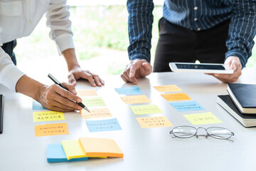 Two Business people meeting and planning use post it notes to share idea