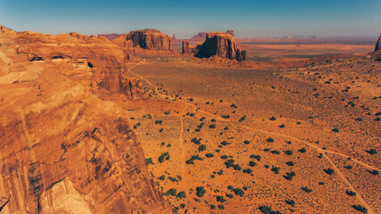 Fototapeta premium Bird's eye scenery view of unique geological formation of Arizona landmark. Monument Valley rocks one of the National symbols of the United States of America. Sandy desert landscape with roads