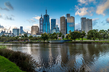 Fototapeta na wymiar Melbourne, Australia - 05th March 2020: A german photographer walking along the river, taking pictures of the skyline before sunset.