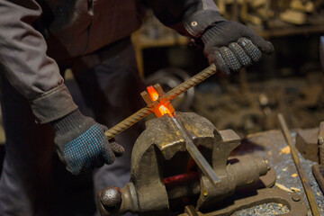 Professional blacksmith working with metal at forge, workshop. Handmade, craftsmanship and...