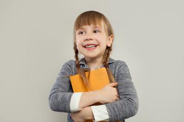 Childlaughing and holding book on white background