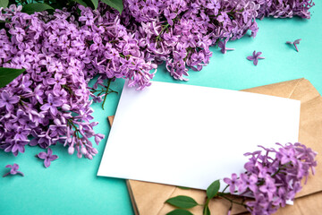 Branches and flowers of lilac and white blank paper for text on a green background. Blank for cards for spring, Easter, mother's day, women's day, Valentine's day.