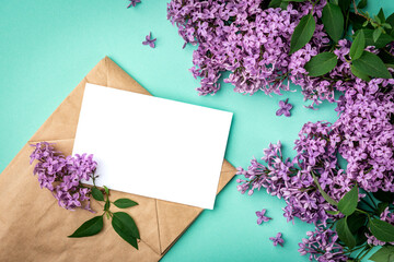 Branches and flowers of lilac and white blank paper for text on a green background. Blank for cards for spring, Easter, mother's day, women's day, Valentine's day.