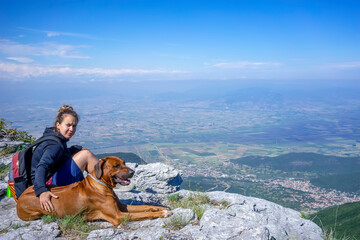Girl with a Rhodesian ridgeback dog in the mountains