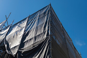 養生シートに覆われた建築現場の風景