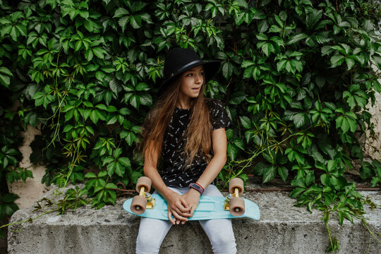 Portrait of little hipster girl with penny board