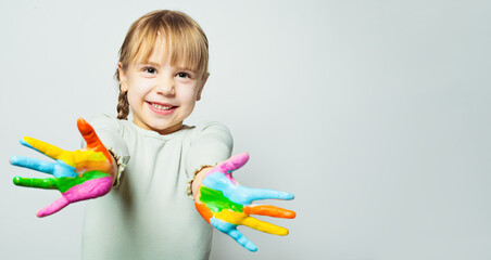 Happy girl showing her colorful painted hands. Child art school student smiling on white background