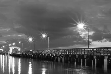 Selbstklebende Fototapete Schwarz und weiss Beleuchteter Pier am frühen Morgen B&amp W