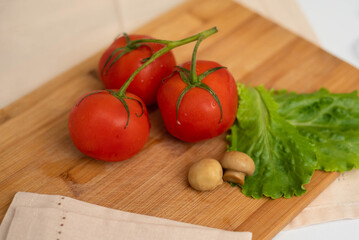 Mushrooms with lettuce and tomatoes on a wooden board.
