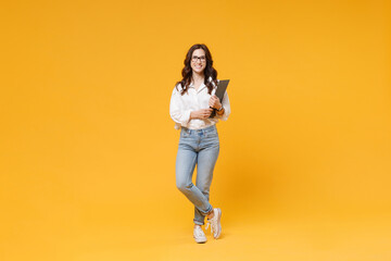 Fototapeta na wymiar Smiling young brunette business woman in white shirt glasses isolated on yellow background studio. Achievement career wealth business concept. Mock up copy space. Hold clipboard with papers document.