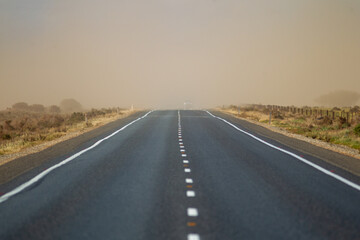 A stretch of highway road with a passing dust storm in country south australia on 20th June 2020