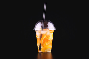 Lemonade to go cup with mint, orange and lemon on black background, isolated