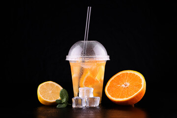 Lemonade to go cup with mint, orange and lemon on black background, isolated