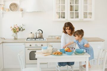 A young mother spends time with her little daughter at home.